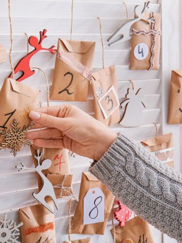 German advent calendar on a wall. Hand picking an envelope from the calendar.